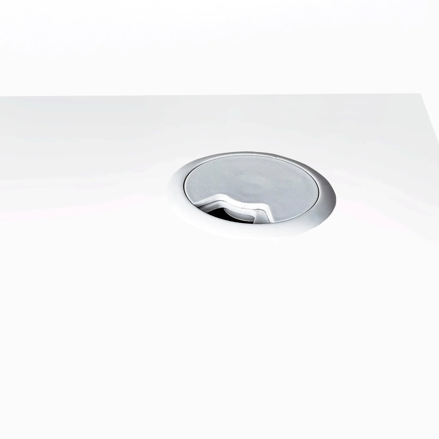 White office desk with built-in cable management grommet close-up