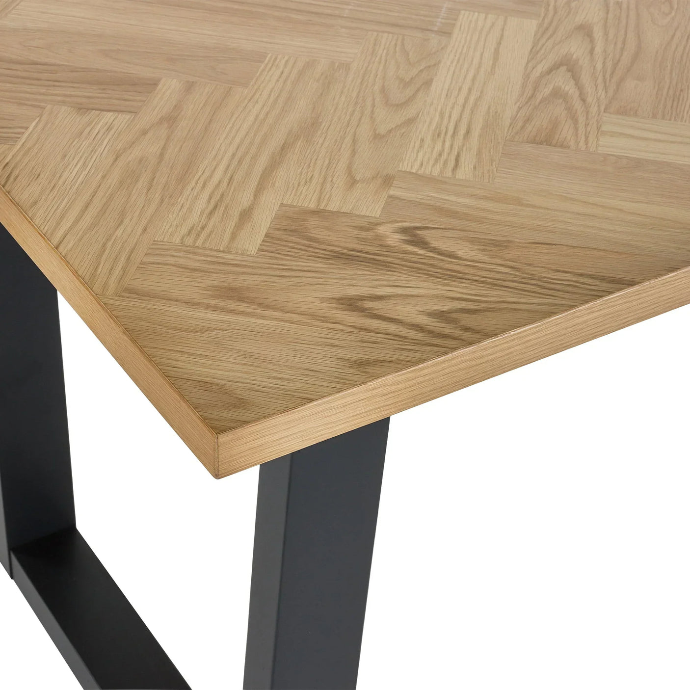 Oak dining table close up showing herringbone pattern and black metal leg