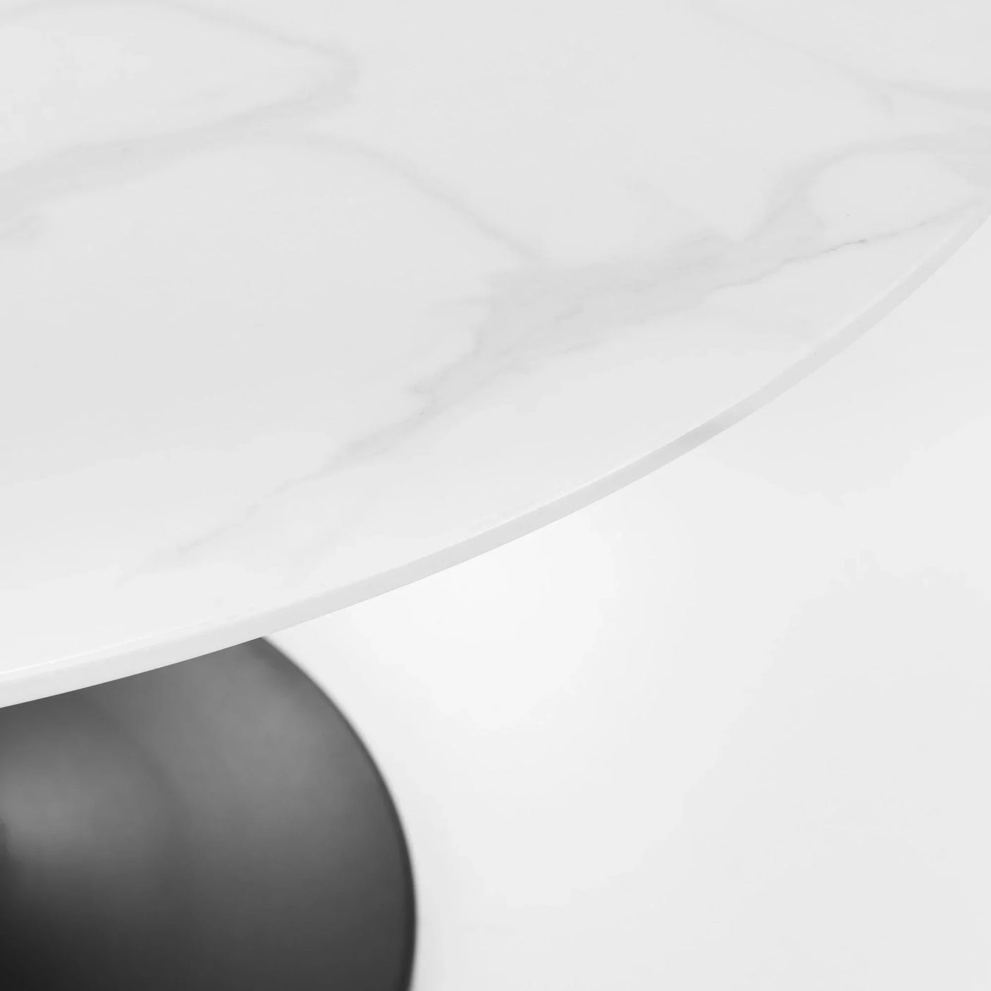 Round marble dining table top with black pedestal base close-up