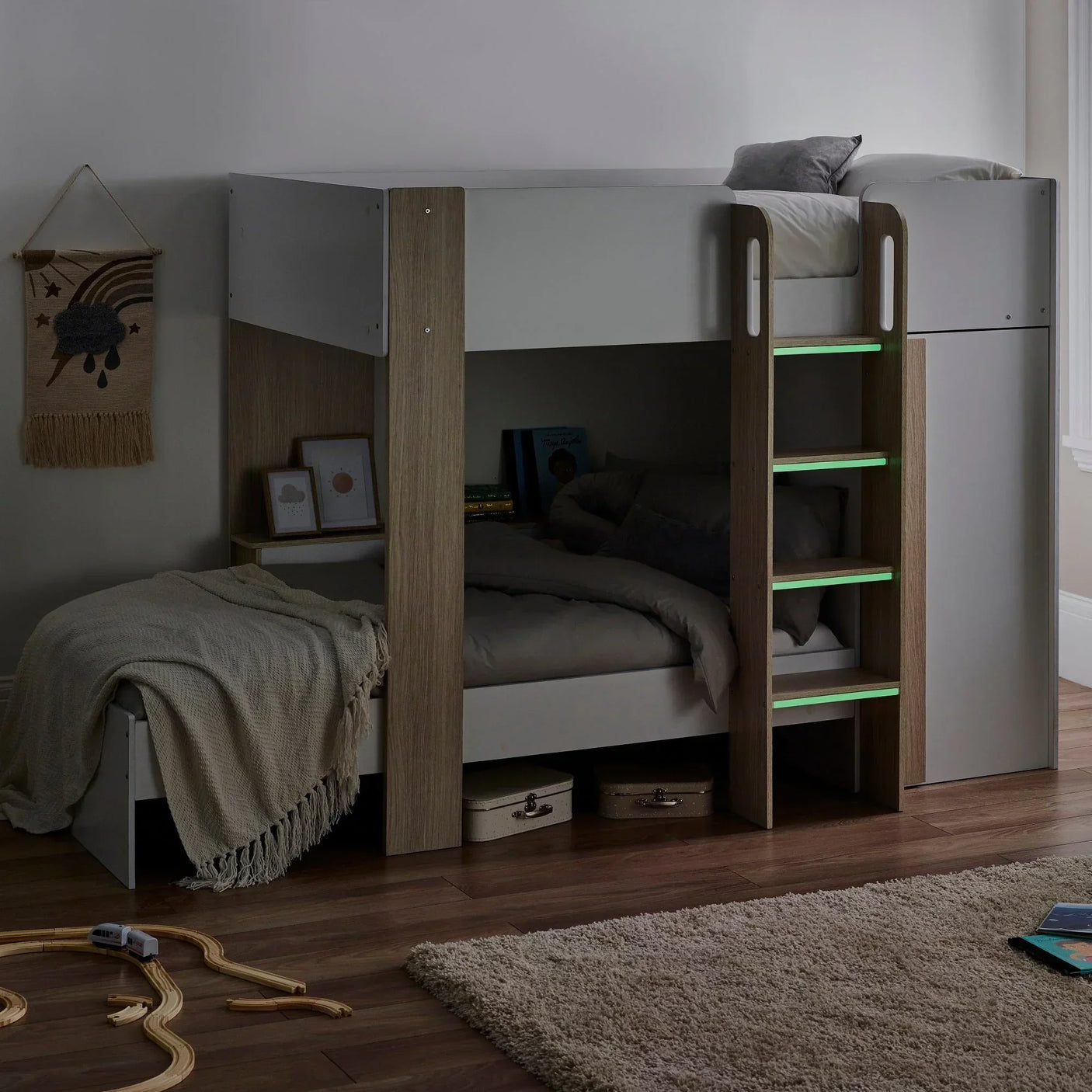 Pale wood bunk bed with ladder in white kids room, bedding and storage underneath