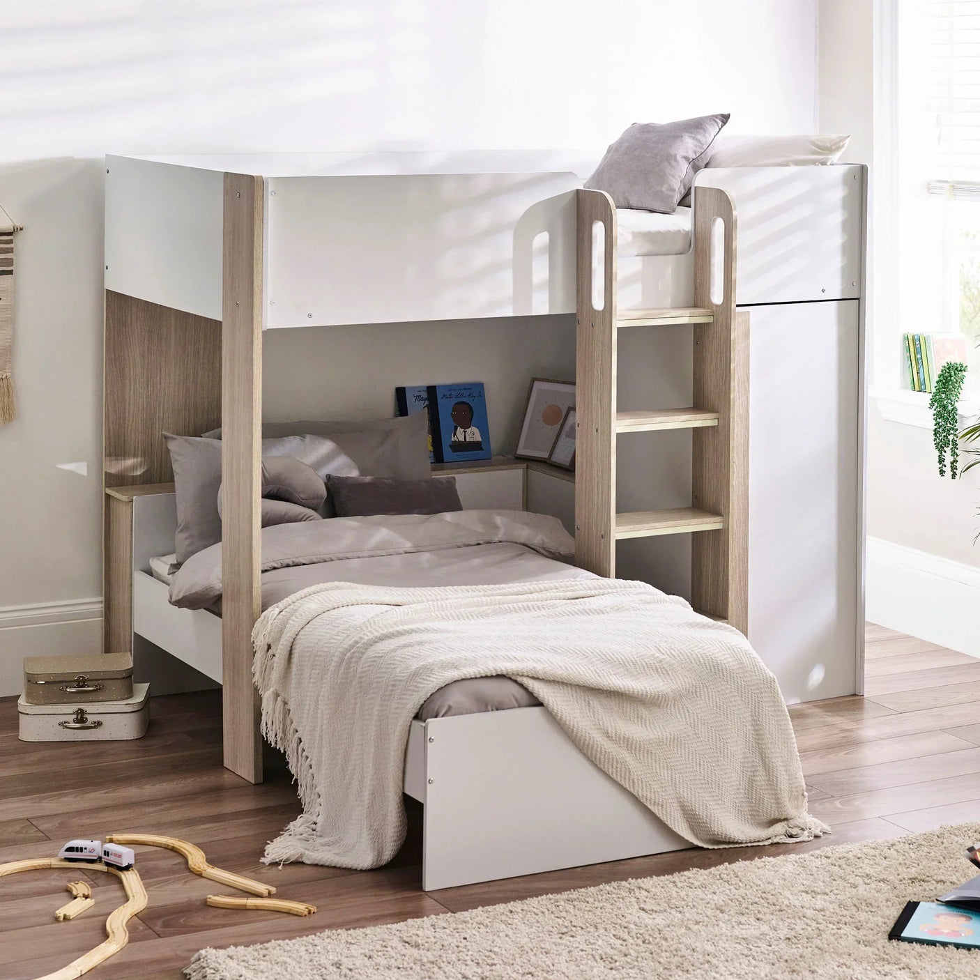 pale wood bunk bed with ladder, grey bedding and underbed storage in bright bedroom