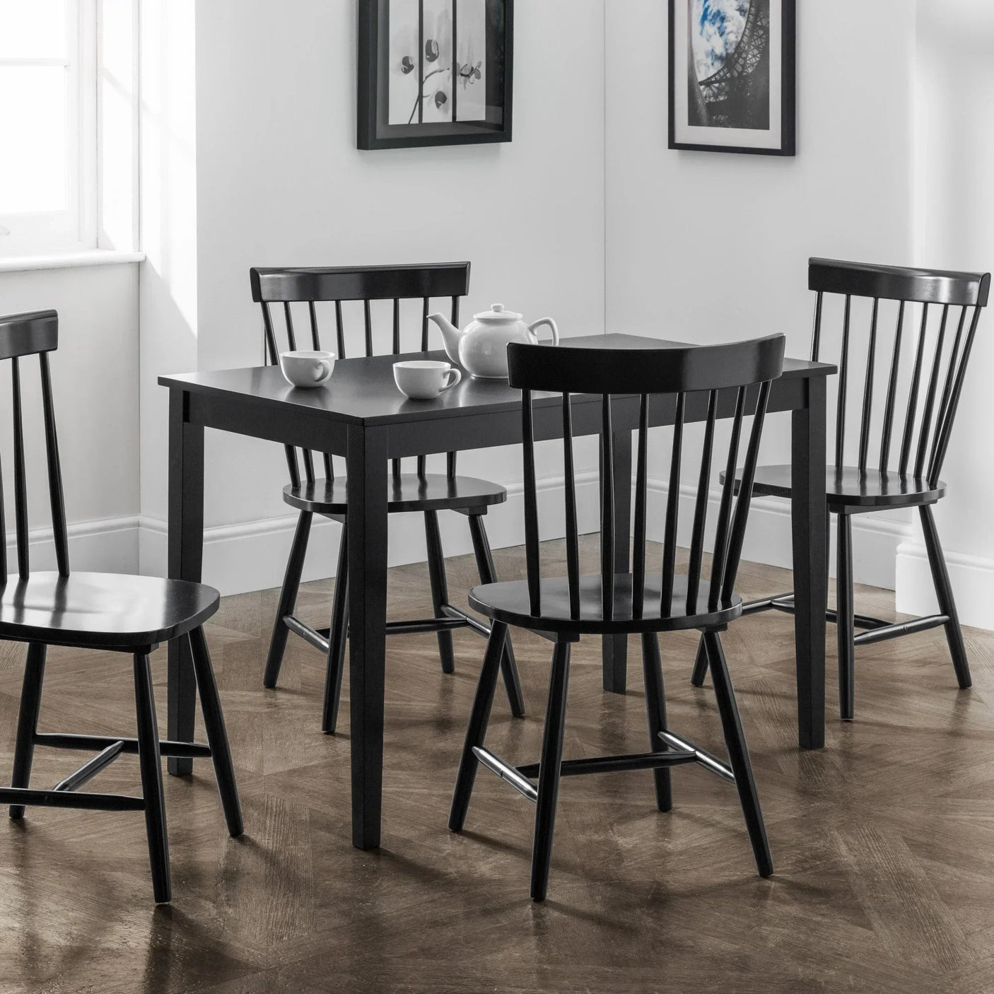 Black wooden dining table with four matching dining chairs in a modern dining room