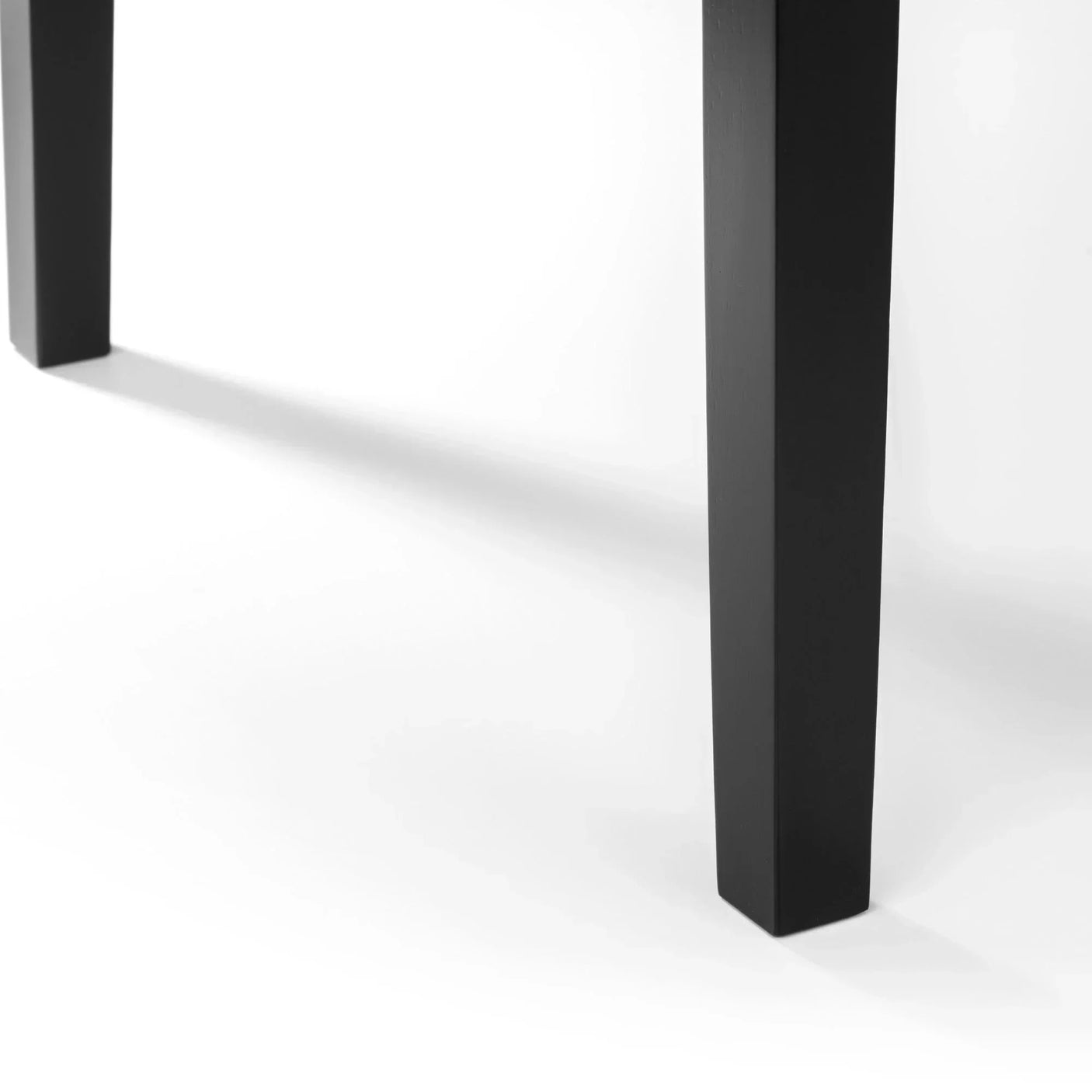 Black wooden dining table legs with straight lines on white background