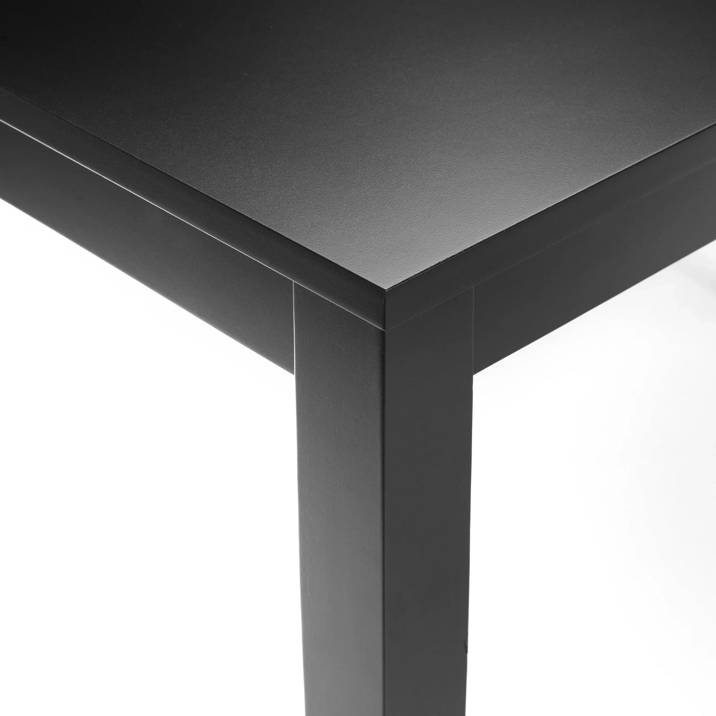 Close-up of black dining table corner with matte finish and sturdy straight legs