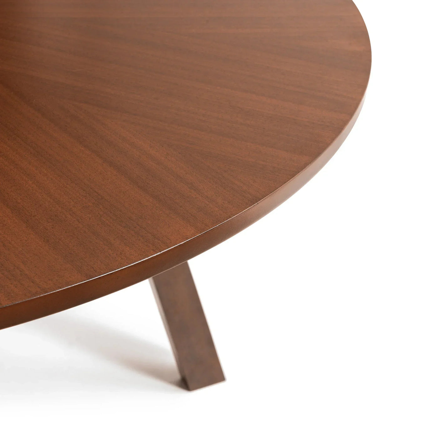 Closeup of round wooden dining table top with angled leg and smooth walnut finish