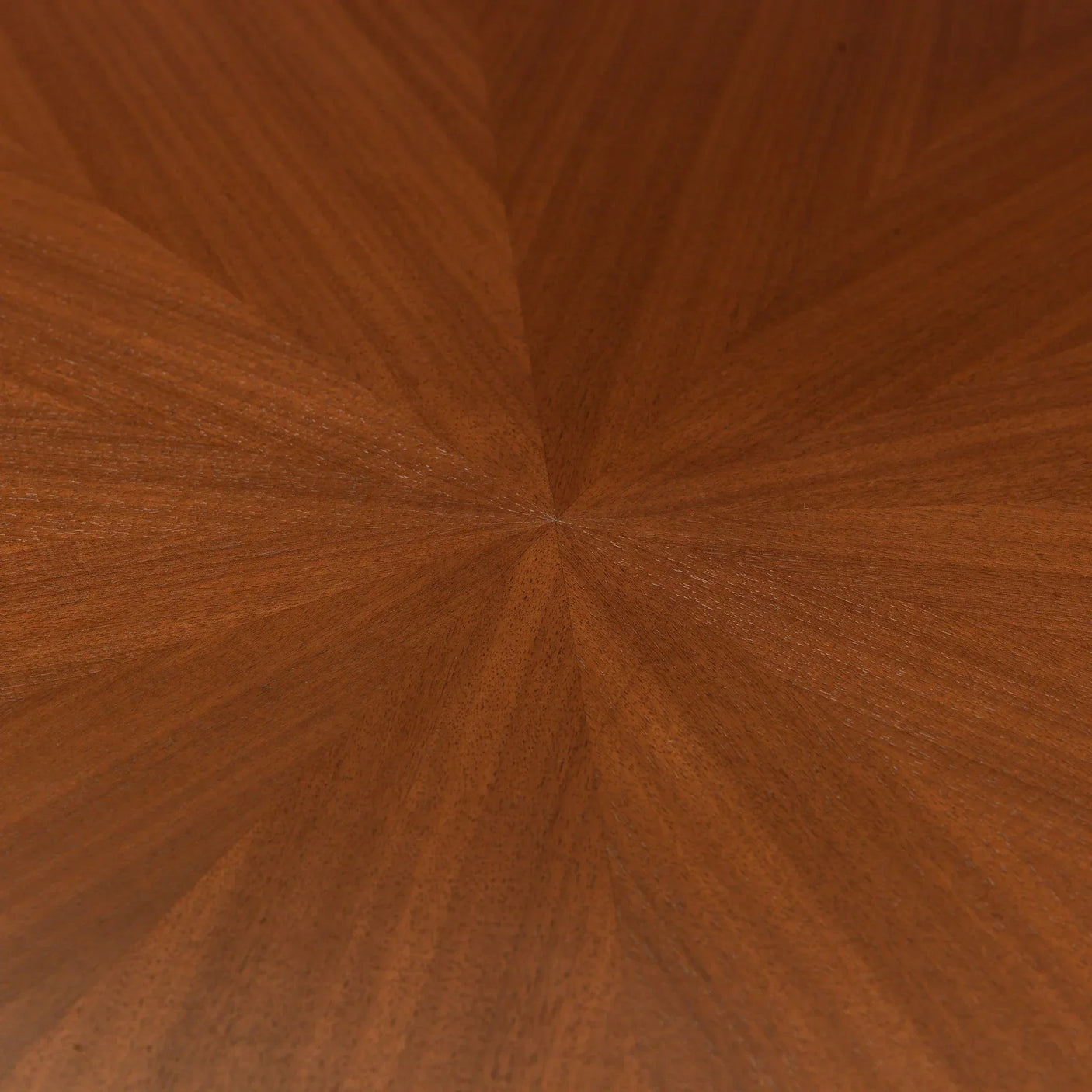 Close-up of wooden dining table top with rich brown starburst veneer pattern