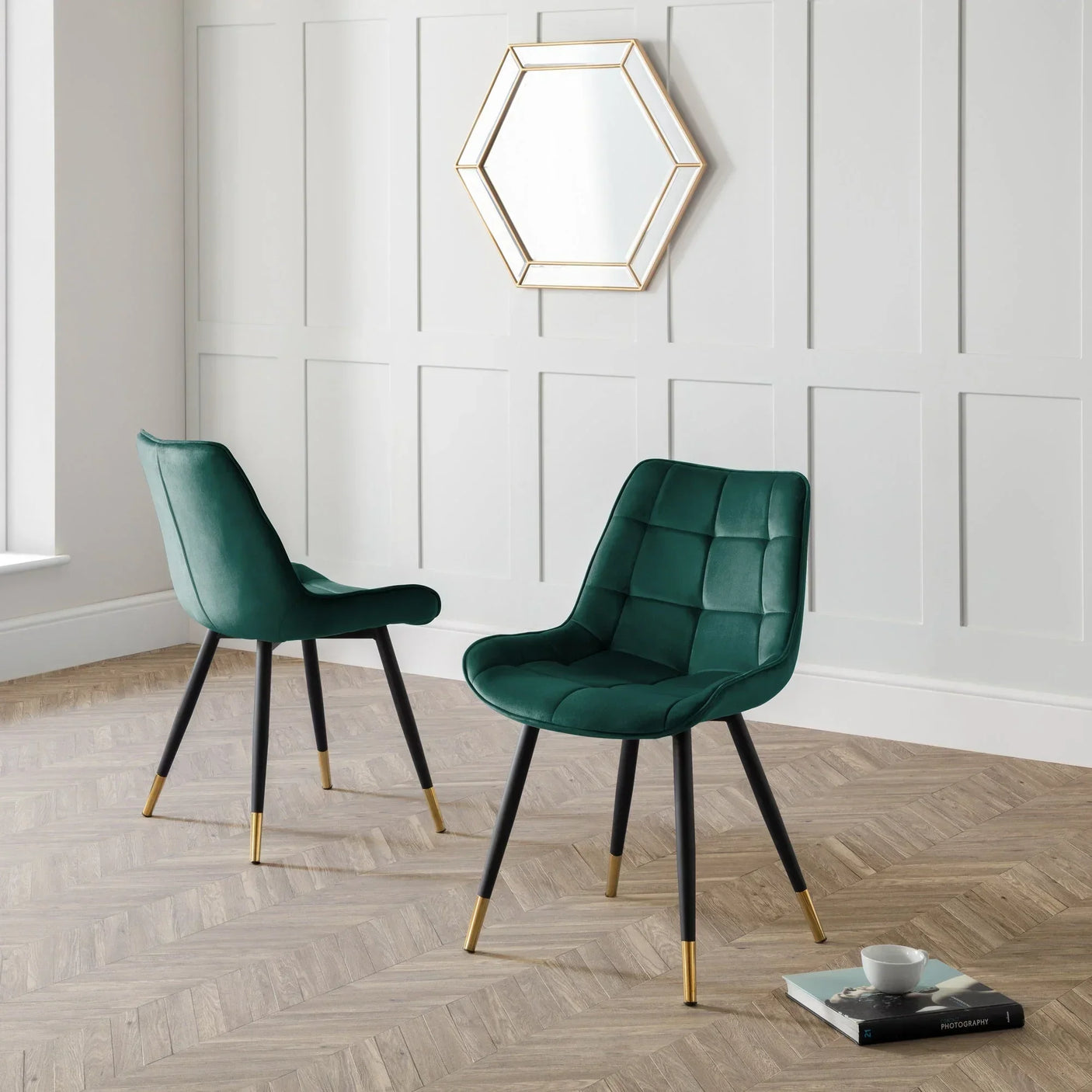 Green velvet accent chair with black and gold legs in modern living room setting