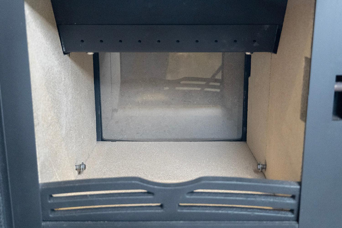Stove interior with firebrick panels and metal grate for wood or solid fuel burning