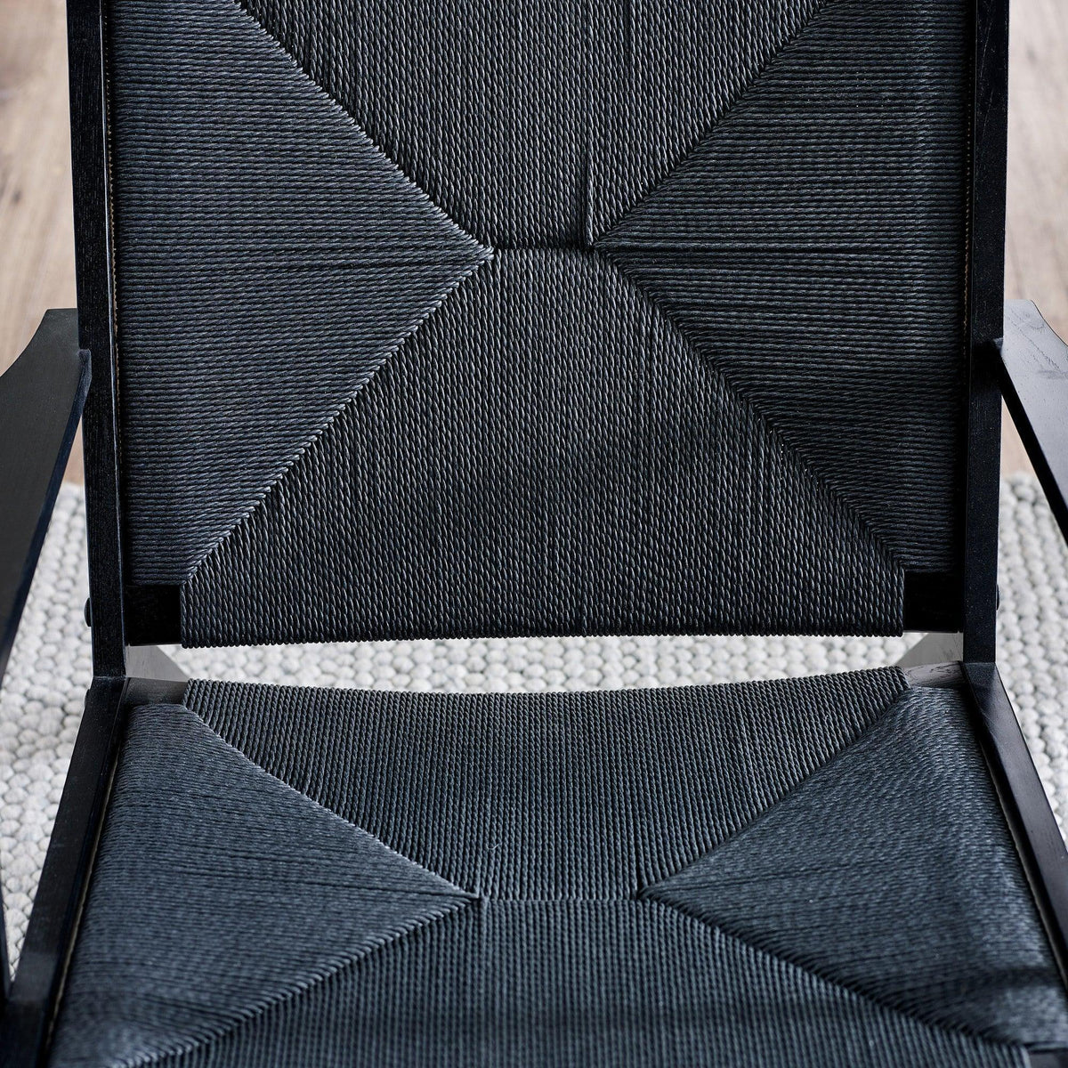Close-up of black woven chair seat and backrest with geometric pattern