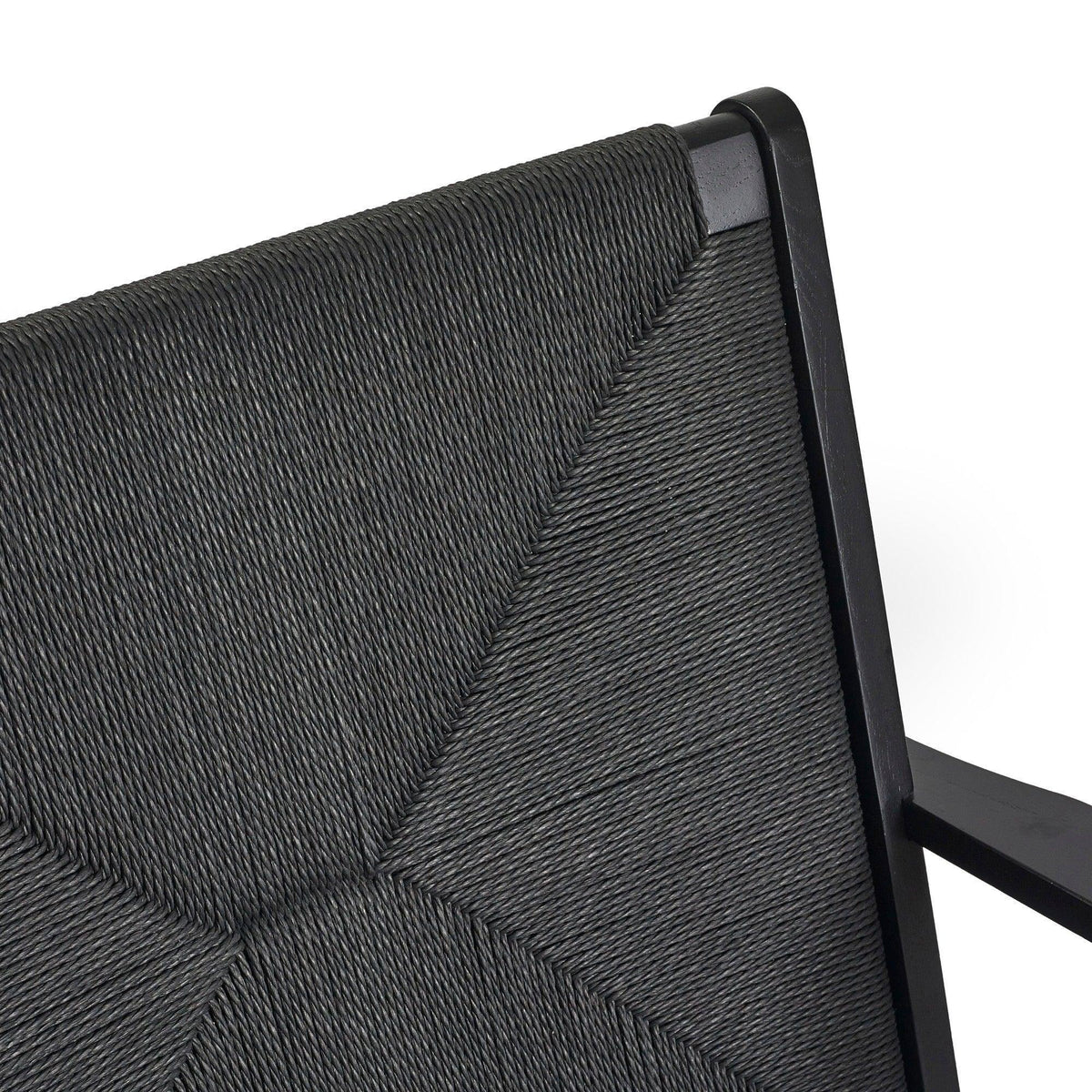 Close-up of black woven dining chair backrest with geometric pattern and wooden frame