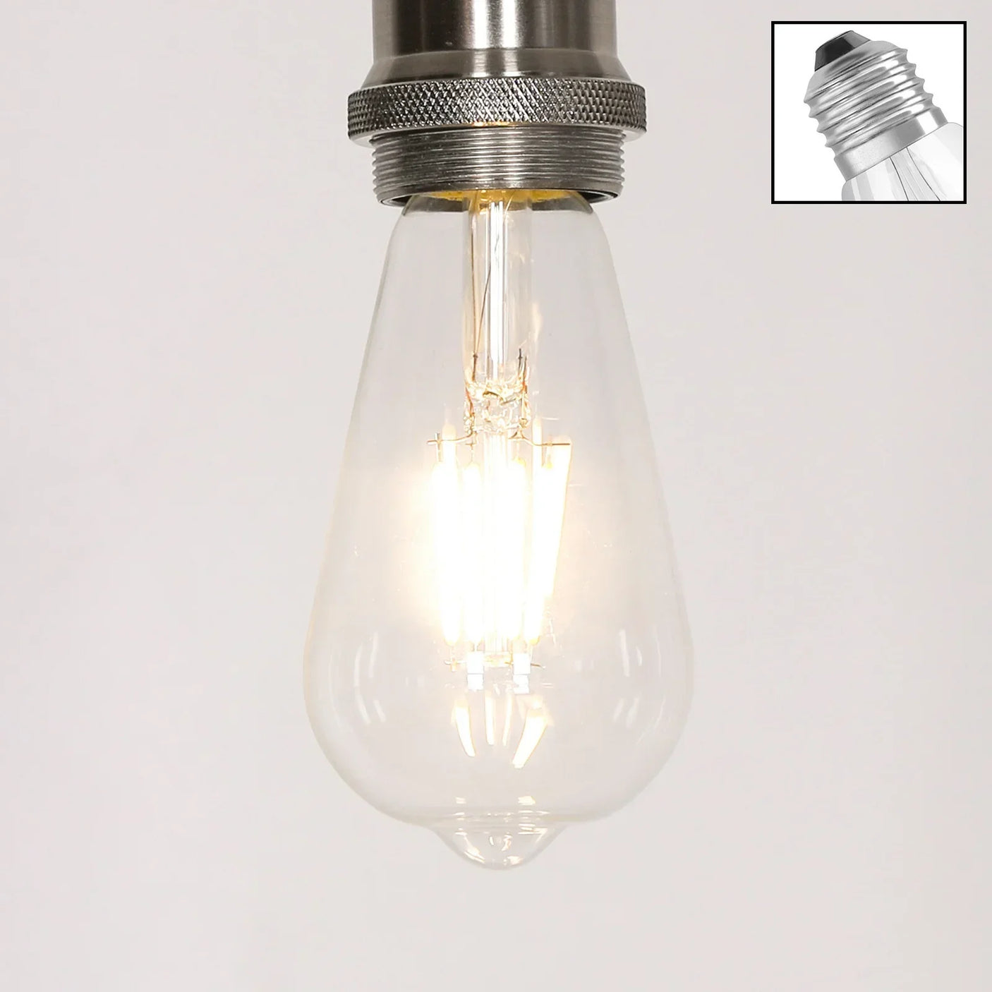 LED filament light bulb with clear glass and visible screw base, switched on