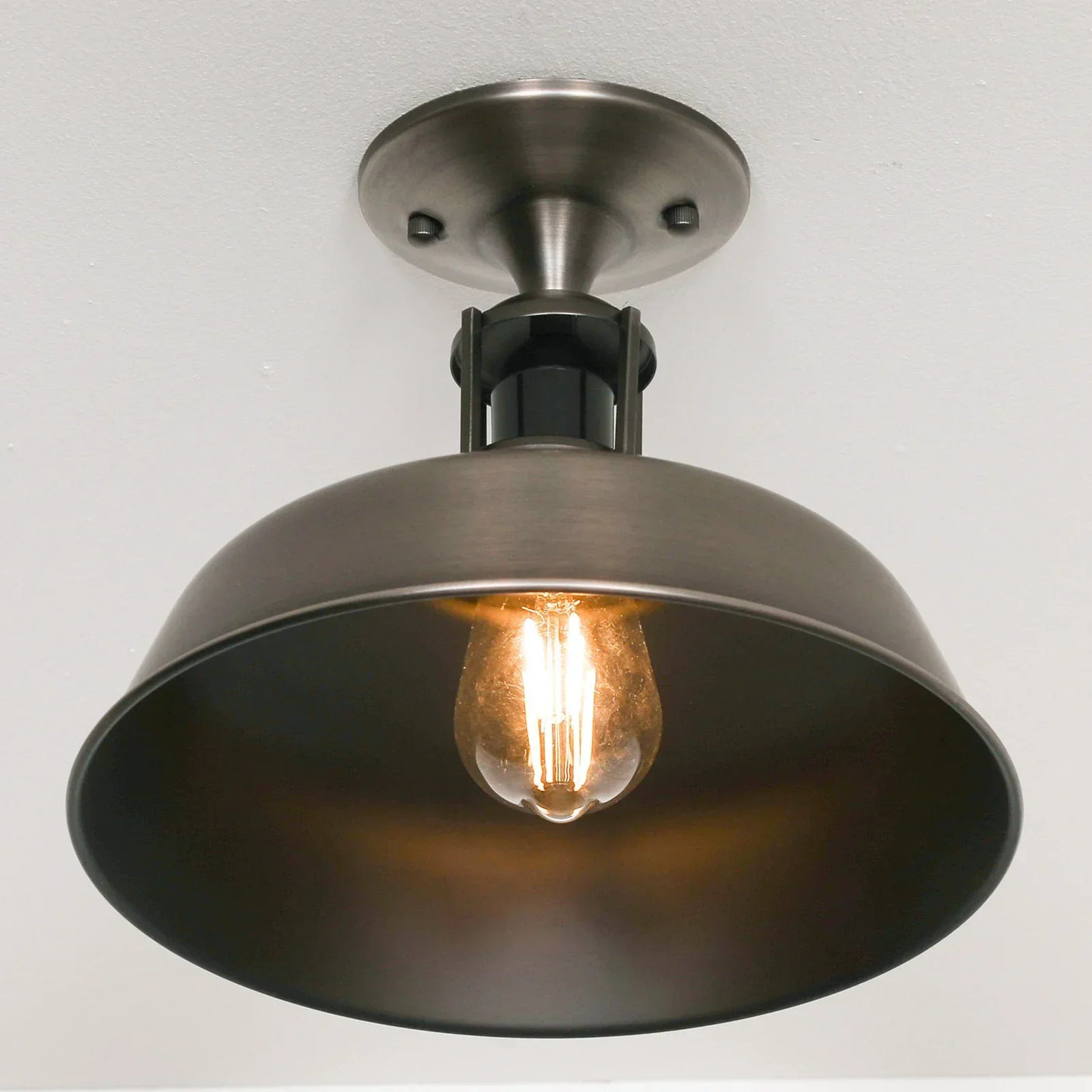 Industrial ceiling light fixture with exposed bulb and black metal shade