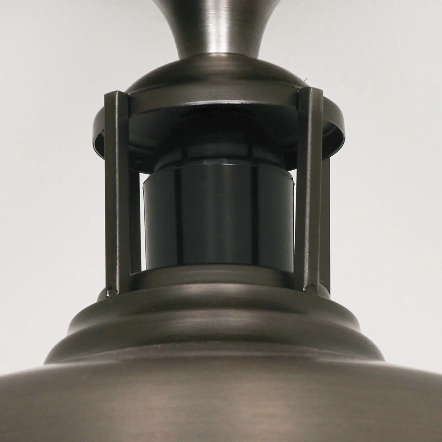 Brushed metal pendant light closeup showing dark steel finish and industrial detailing