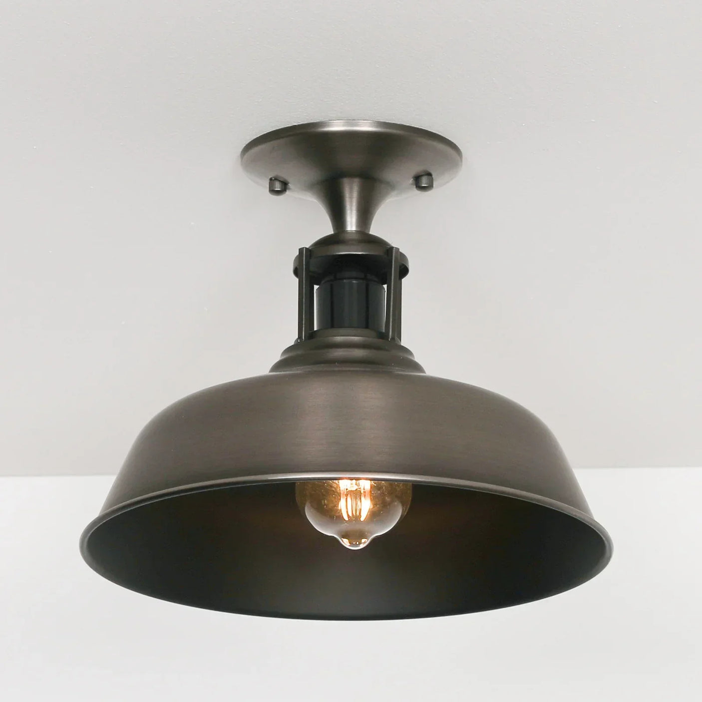 Brushed metal ceiling light fixture with exposed bulb and dome shade
