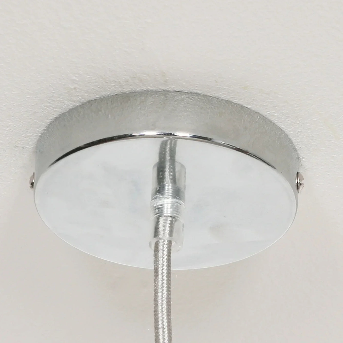 Chrome ceiling light fitting with metallic braided cable close-up