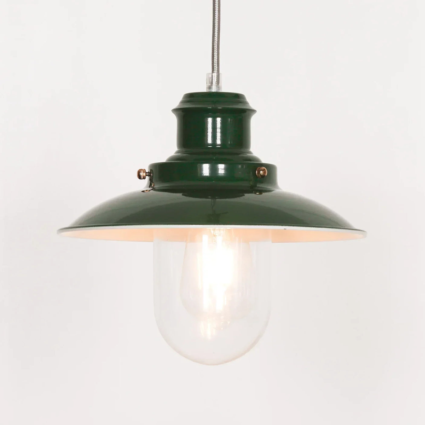 Green metal pendant light with exposed bulb and glass shade, viewed from the front