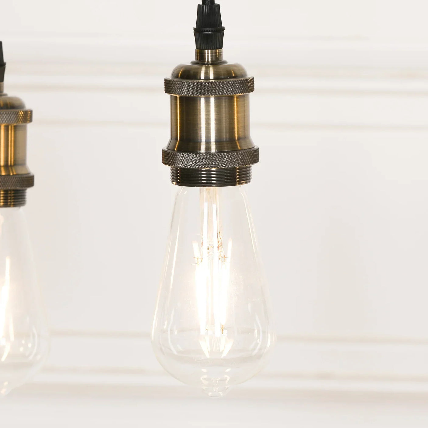 Vintage style pendant light with exposed filament bulb and brass metal fitting