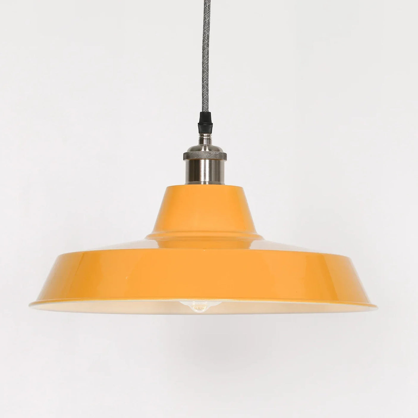 Yellow metal pendant light with wide shade and braided cable, shown against white background