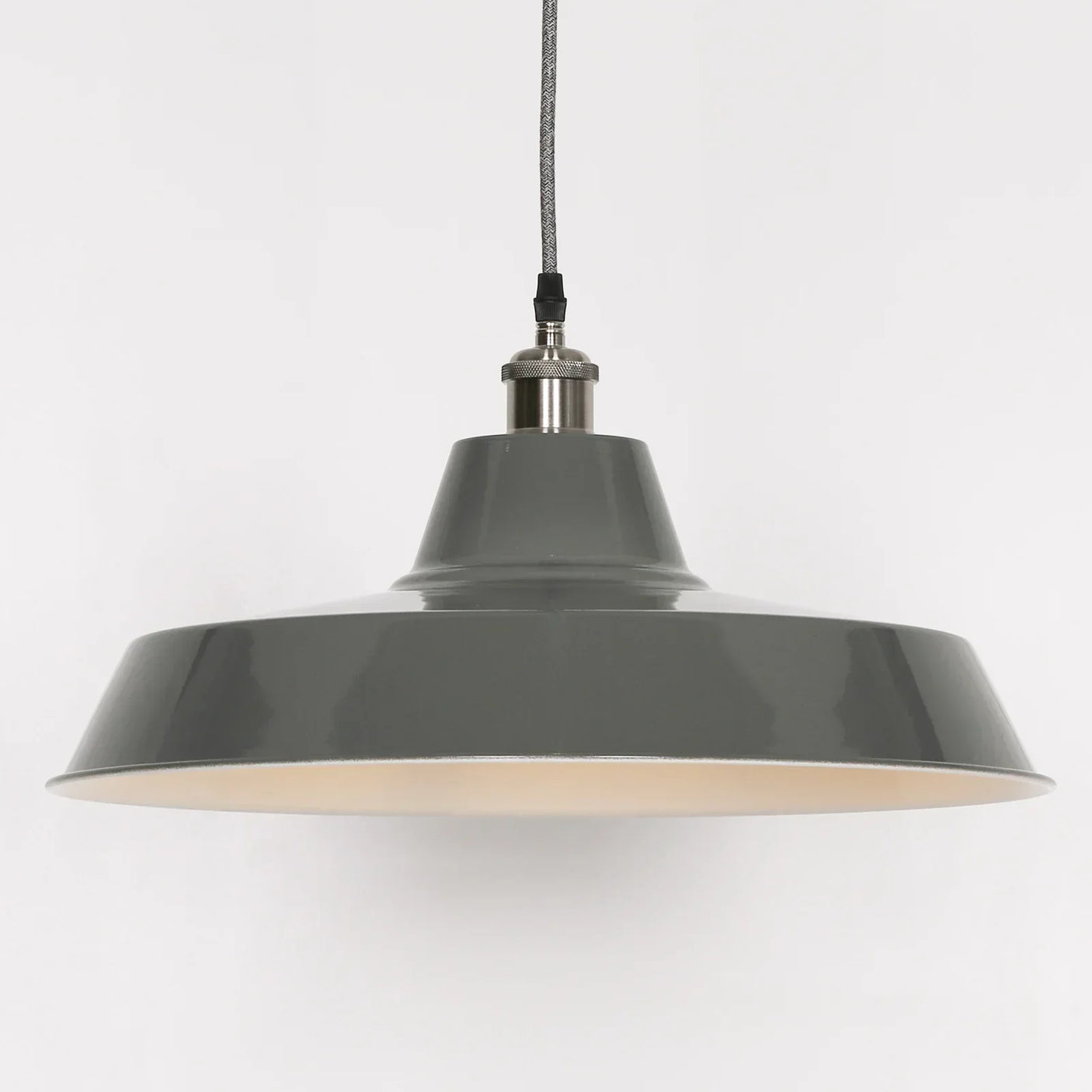 Grey metal pendant light with wide shade and visible hanging cord against white background