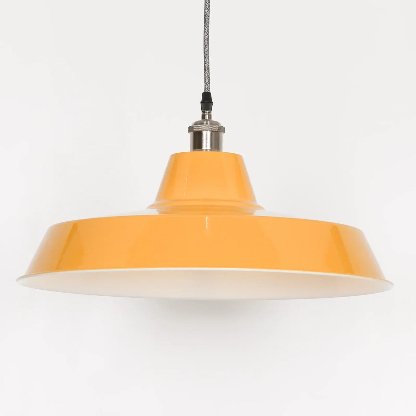 Yellow metal pendant light with chrome fitting and fabric cable against white background