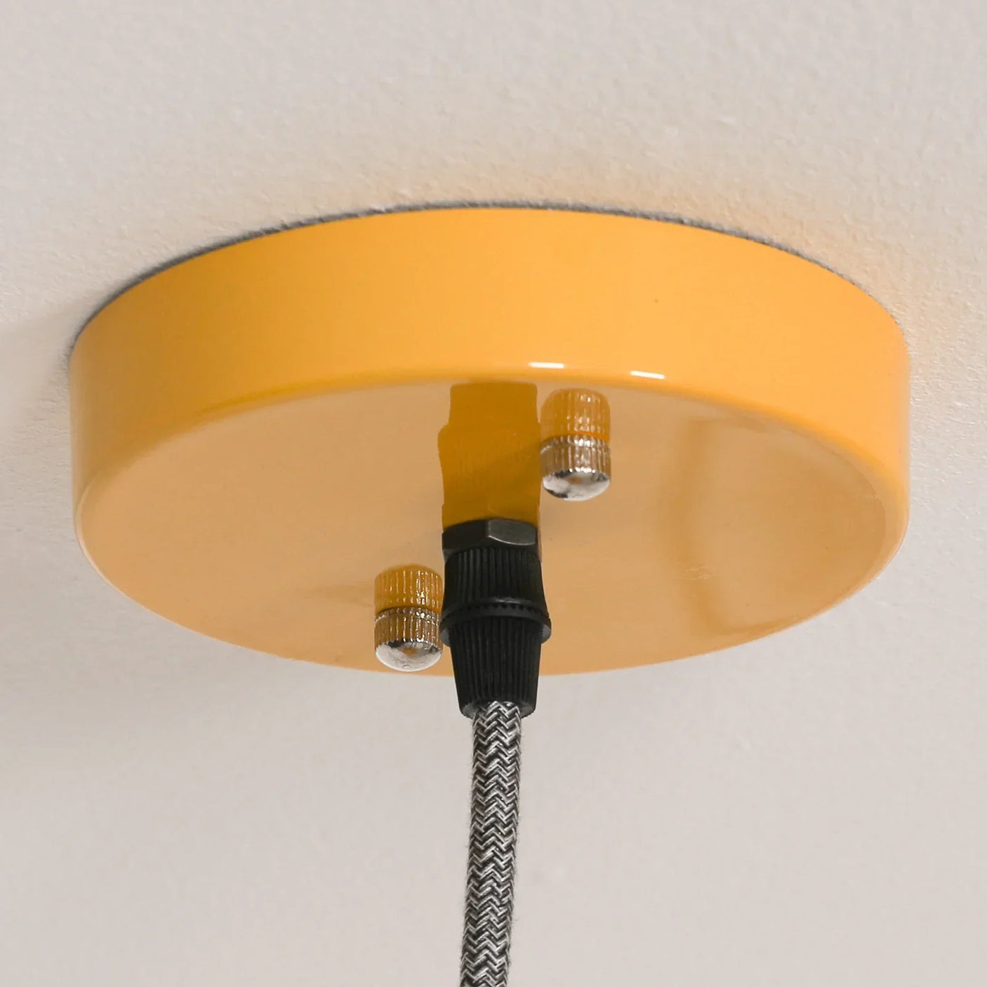 Yellow ceiling light fixture with cord and chevron patterned cable detail