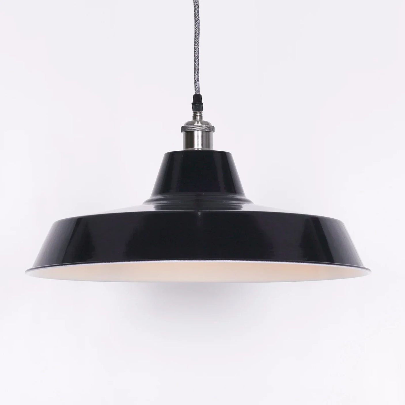 Black metal pendant light with wide shade and braided hanging cord against white background