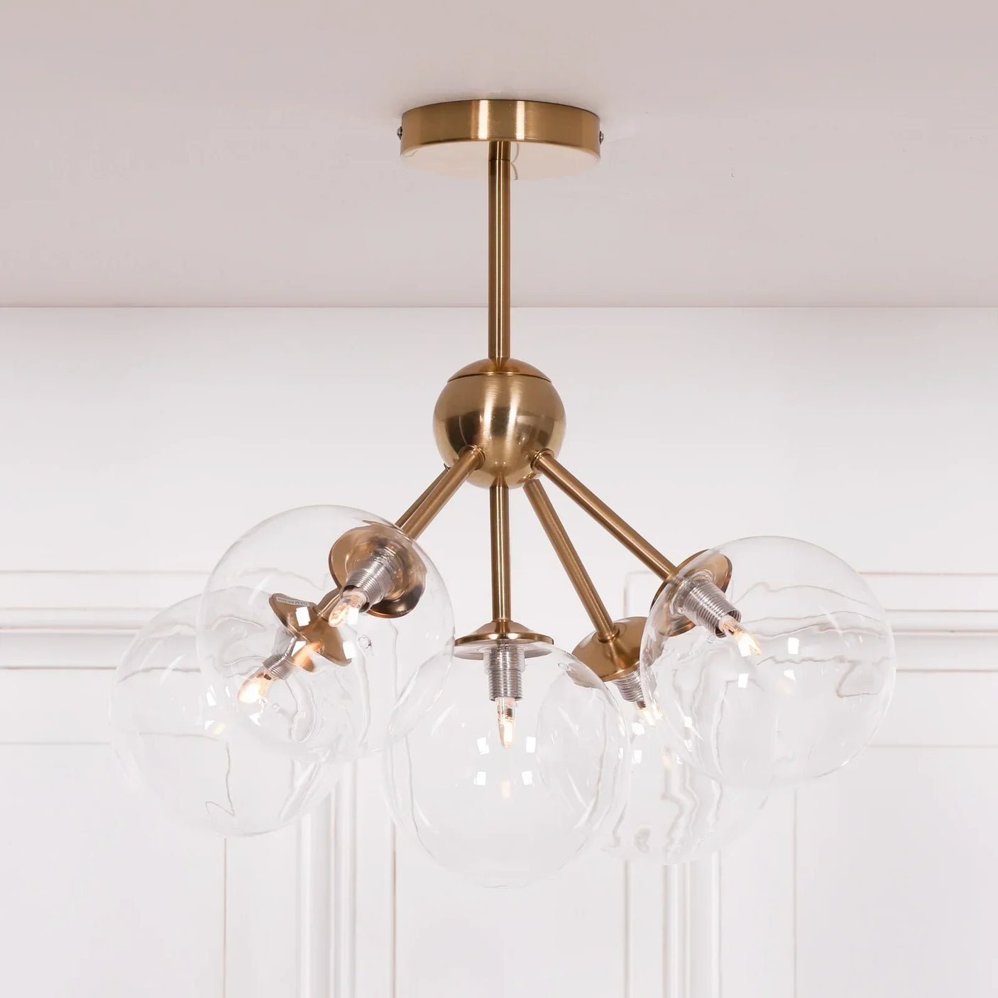 Brass ceiling light with five clear glass globe shades in modern style