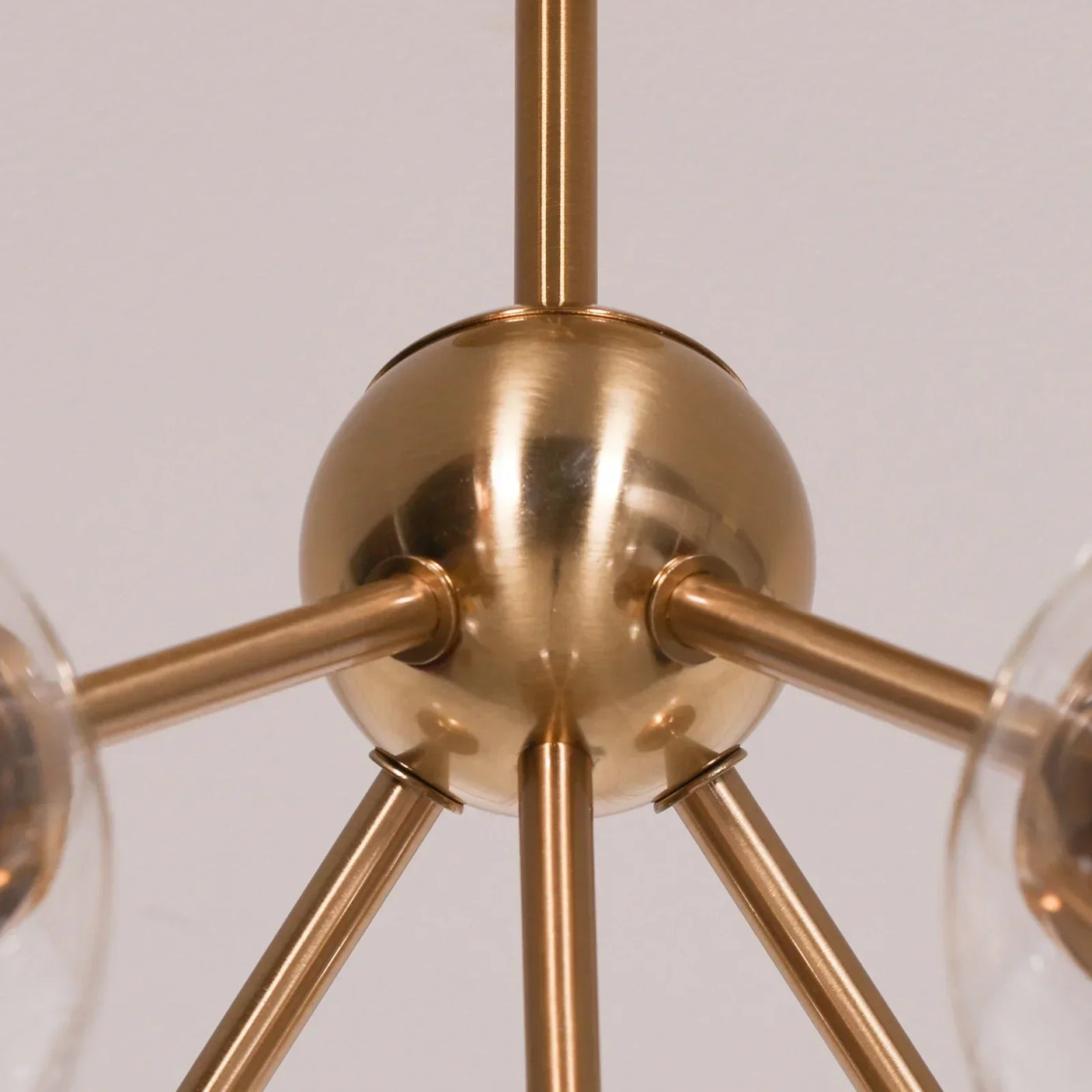 Brushed brass chandelier central sphere with multiple arms extending outward