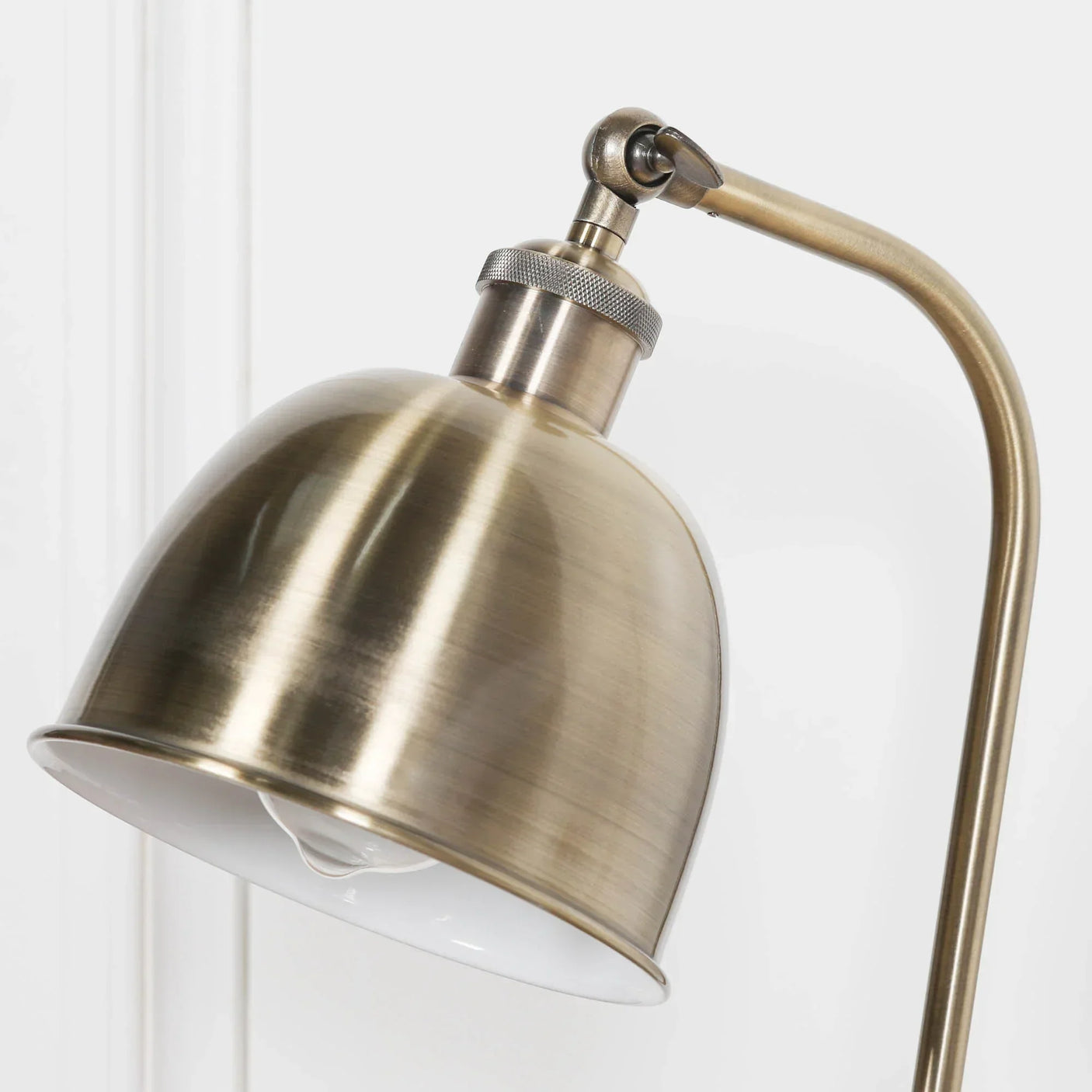 Brushed brass desk lamp with curved arm and adjustable metal shade