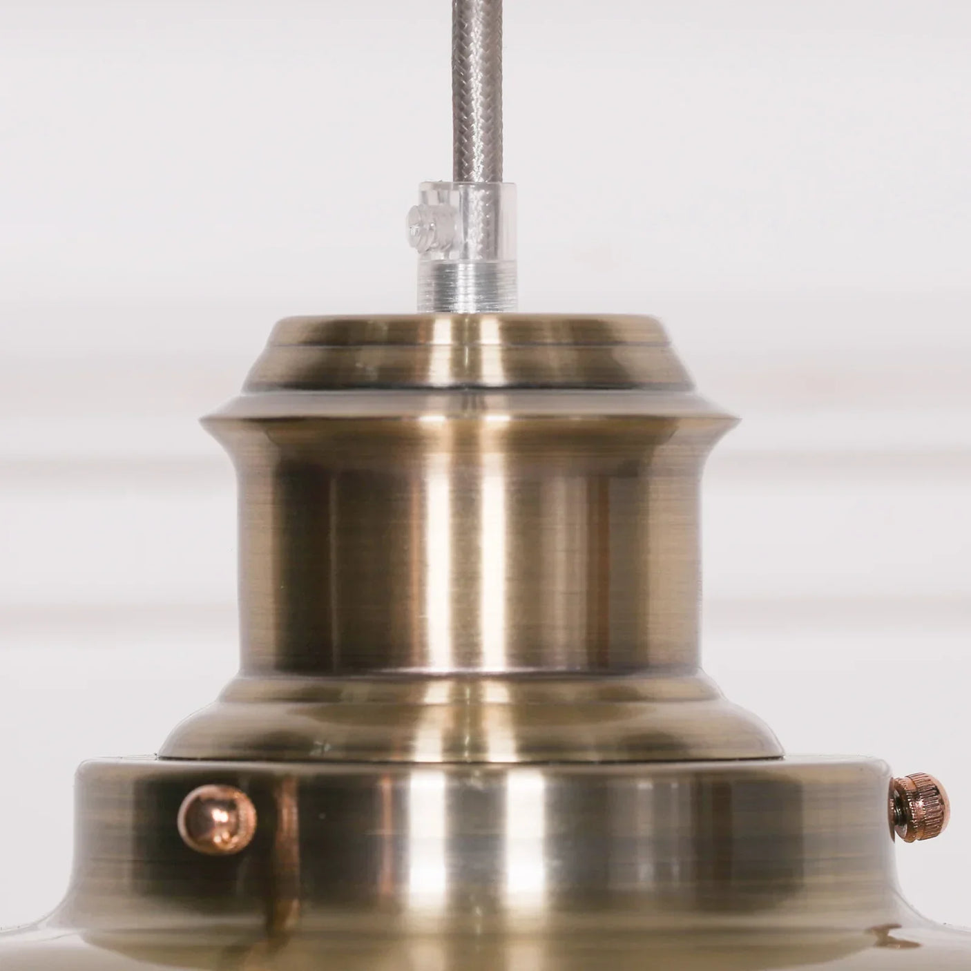 Close-up of brushed brass pendant light fitting with textured metal finish