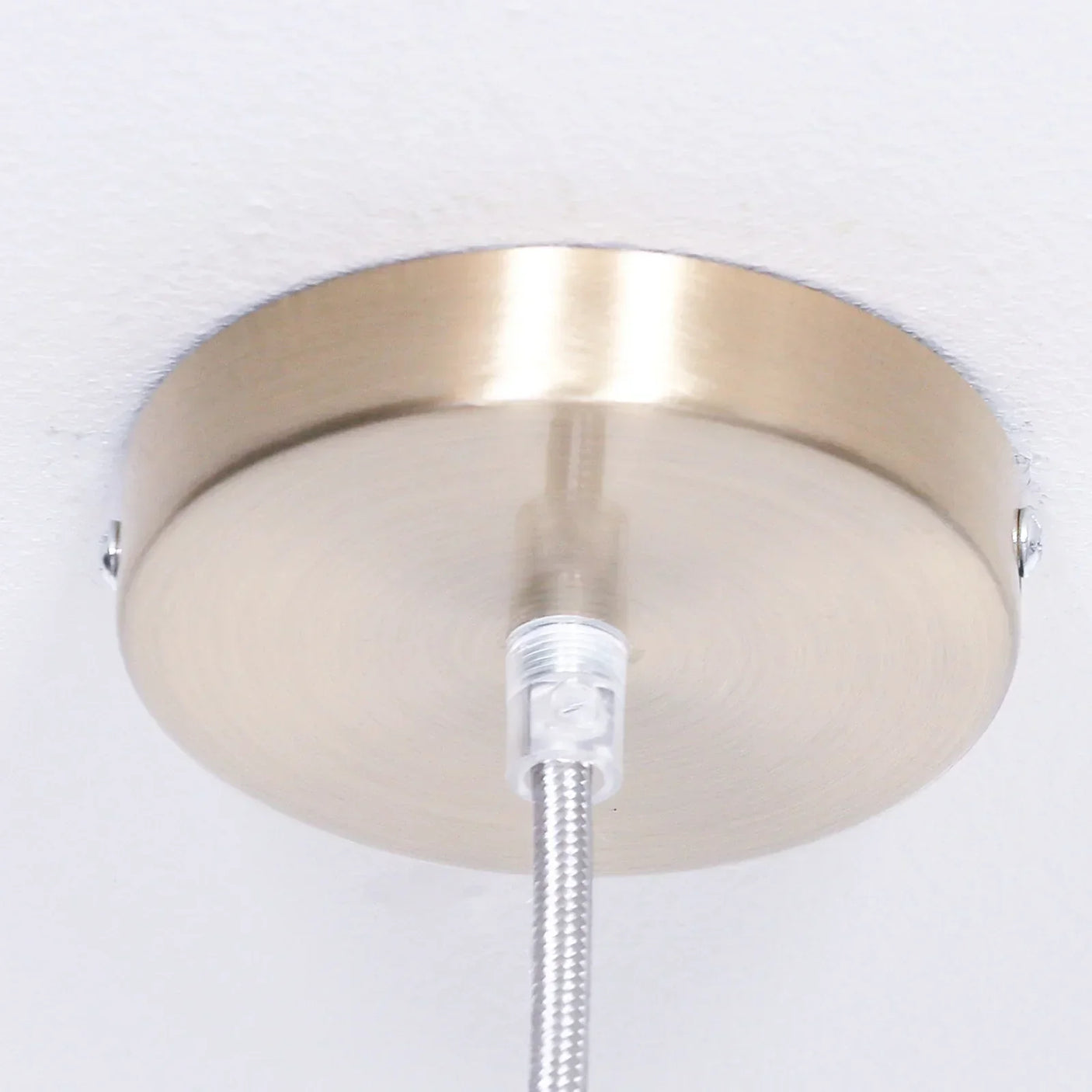 Brushed metal ceiling rose with silver pendant light fitting and cable close-up