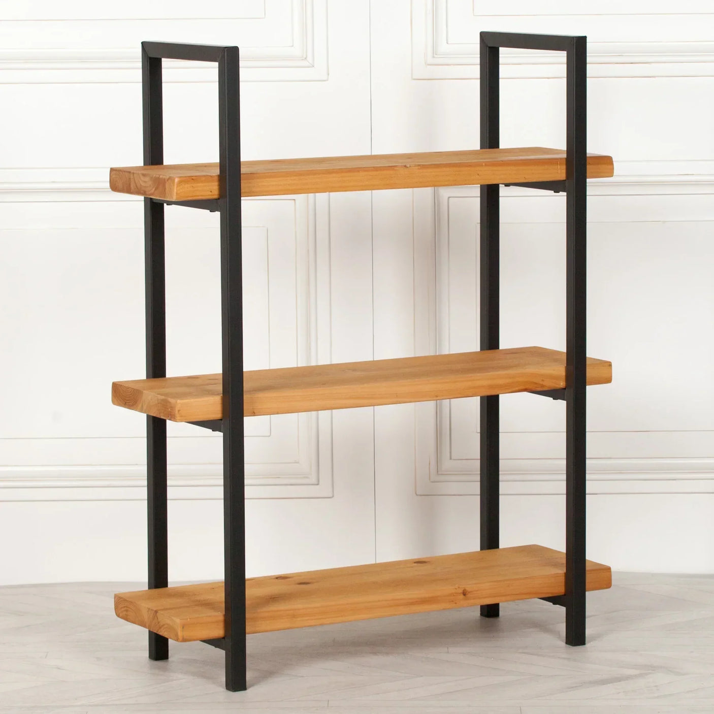 Industrial wood and metal bookshelf with three open shelves against white panel wall