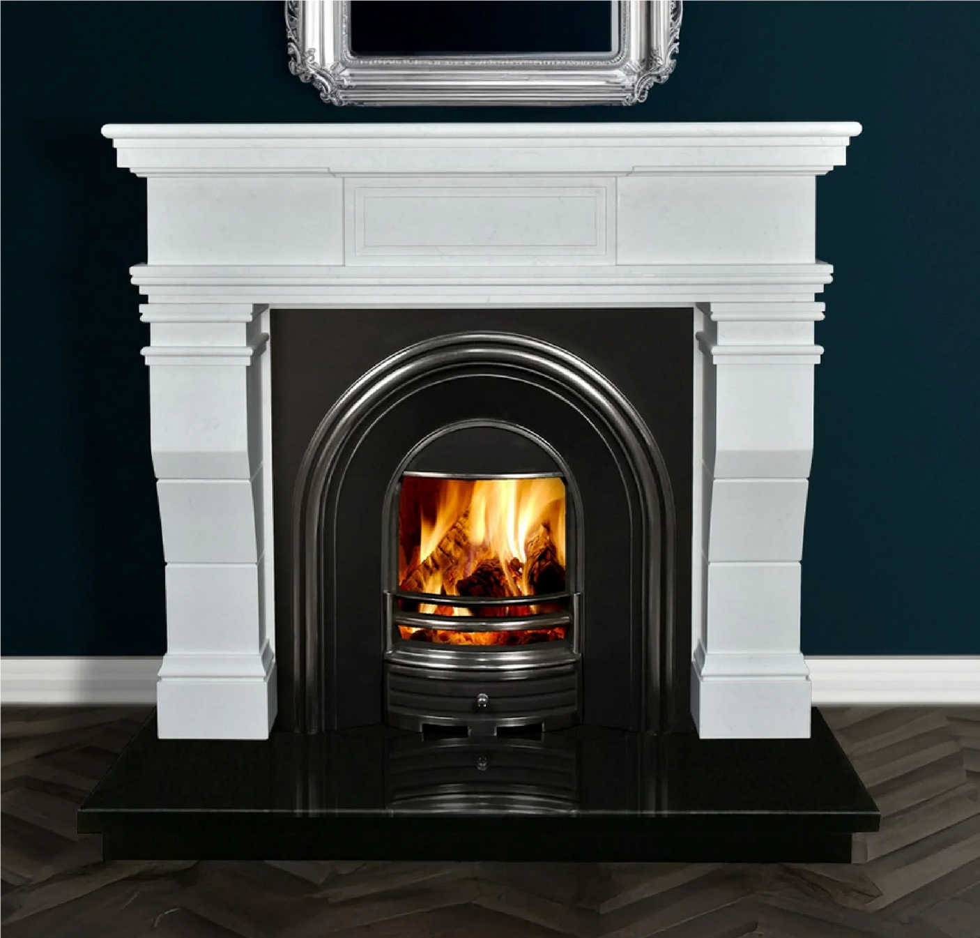 White marble fireplace with black arched insert and real wood fire on dark tile hearth