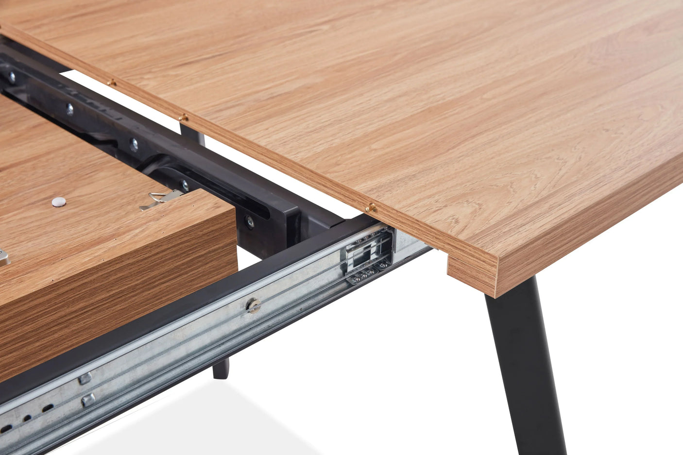 Extendable oak dining table top with metal slide mechanism and black legs, close up view