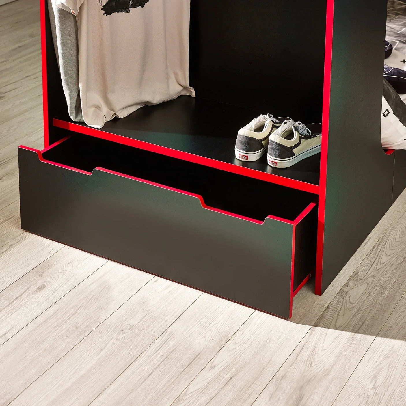 Black and red storage bed drawer with open shelf holding shoes and hanging shirts