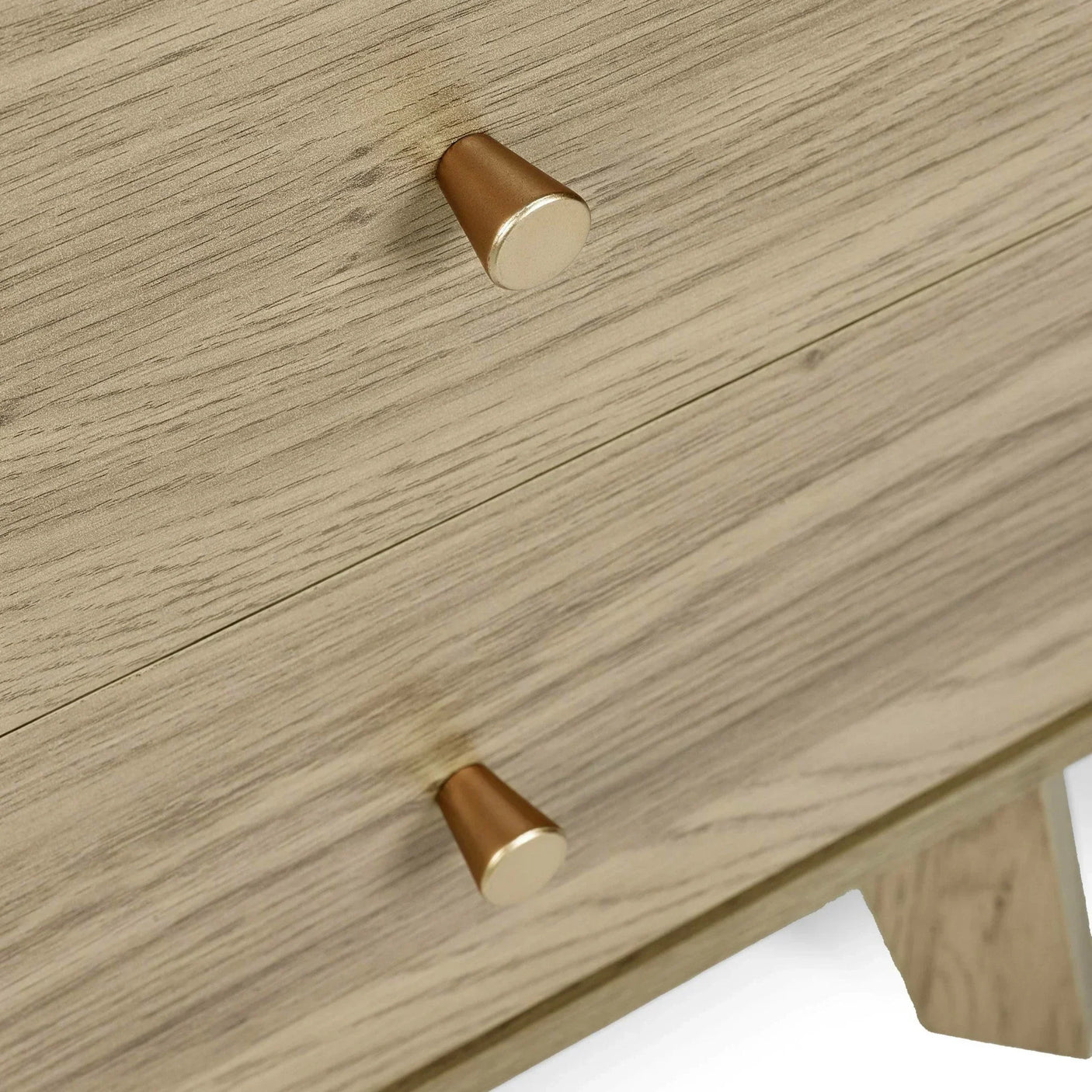 Wooden chest of drawers with gold metal handles, close-up on drawer fronts and knobs