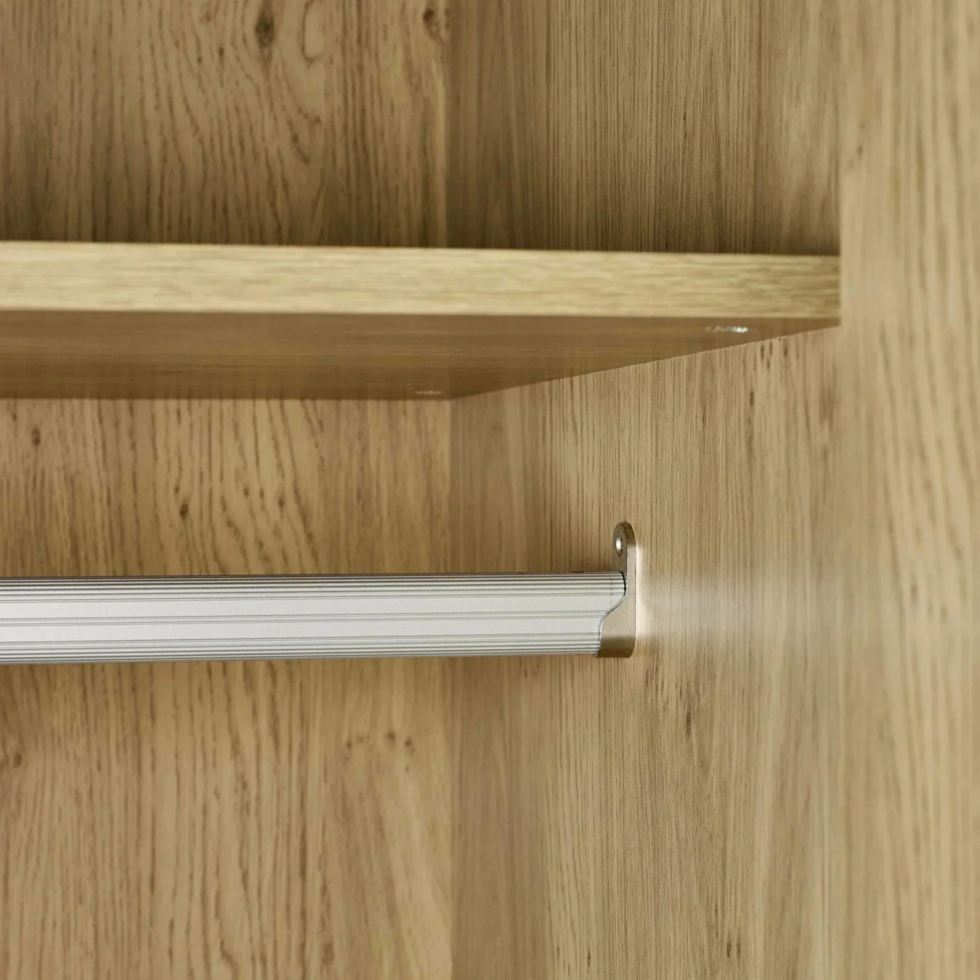 Oak wardrobe interior with shelf and silver hanging rail detail