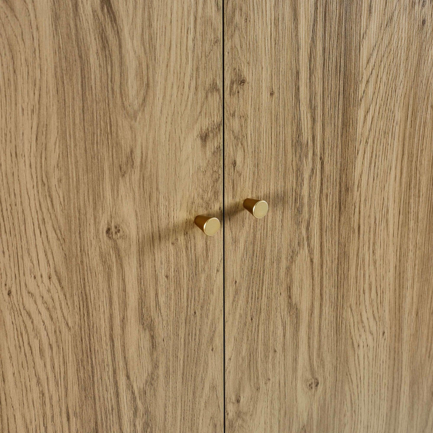 Oak wood cabinet doors with round gold handles, close-up of grain detail and finish