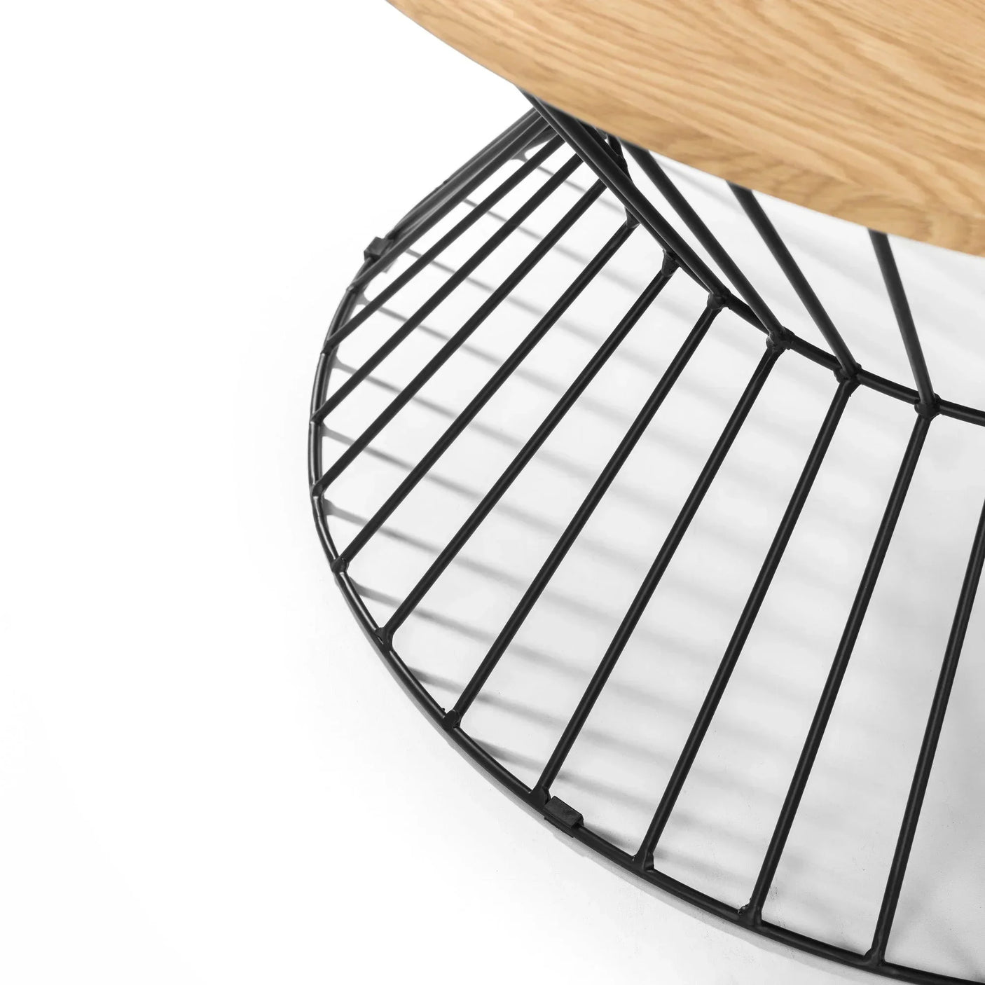 Round side table with black metal wire base and light wood top, close-up angle