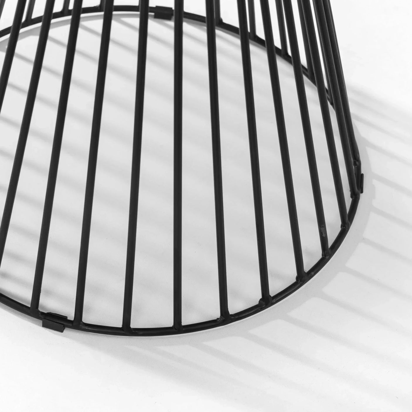 Black metal table base with vertical slats on white background