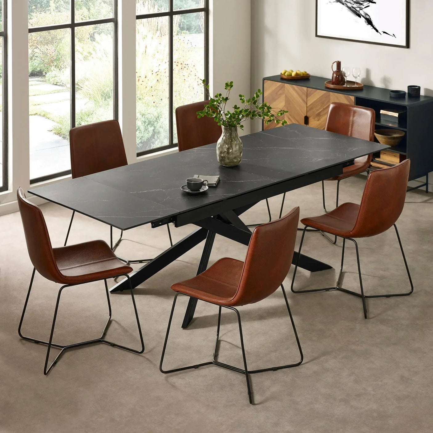 Black dining table with six brown leather chairs in modern dining room setting