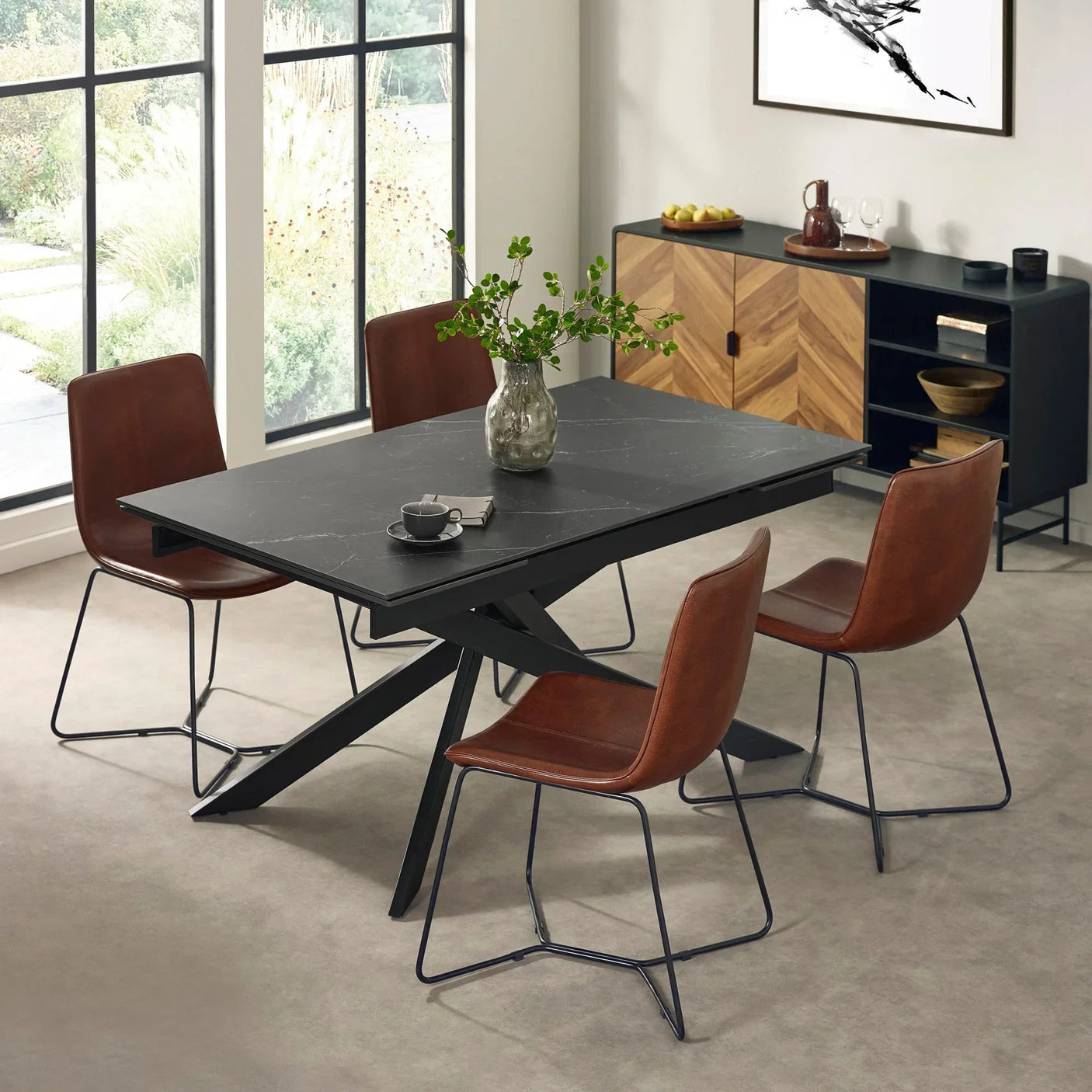 Black dining table with four brown leather chairs in modern dining room