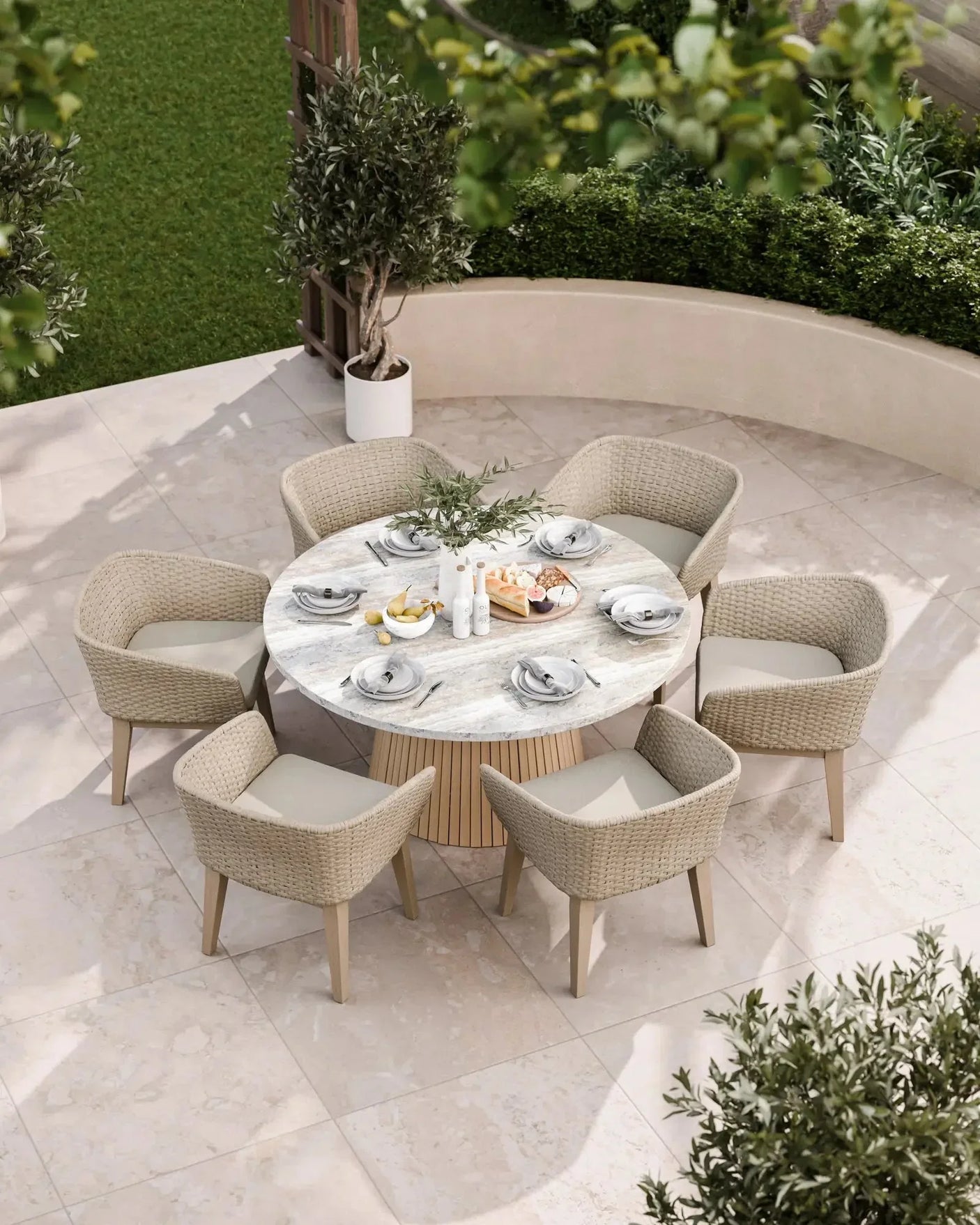 Round marble outdoor dining table with six wicker chairs on a patio, set for a meal