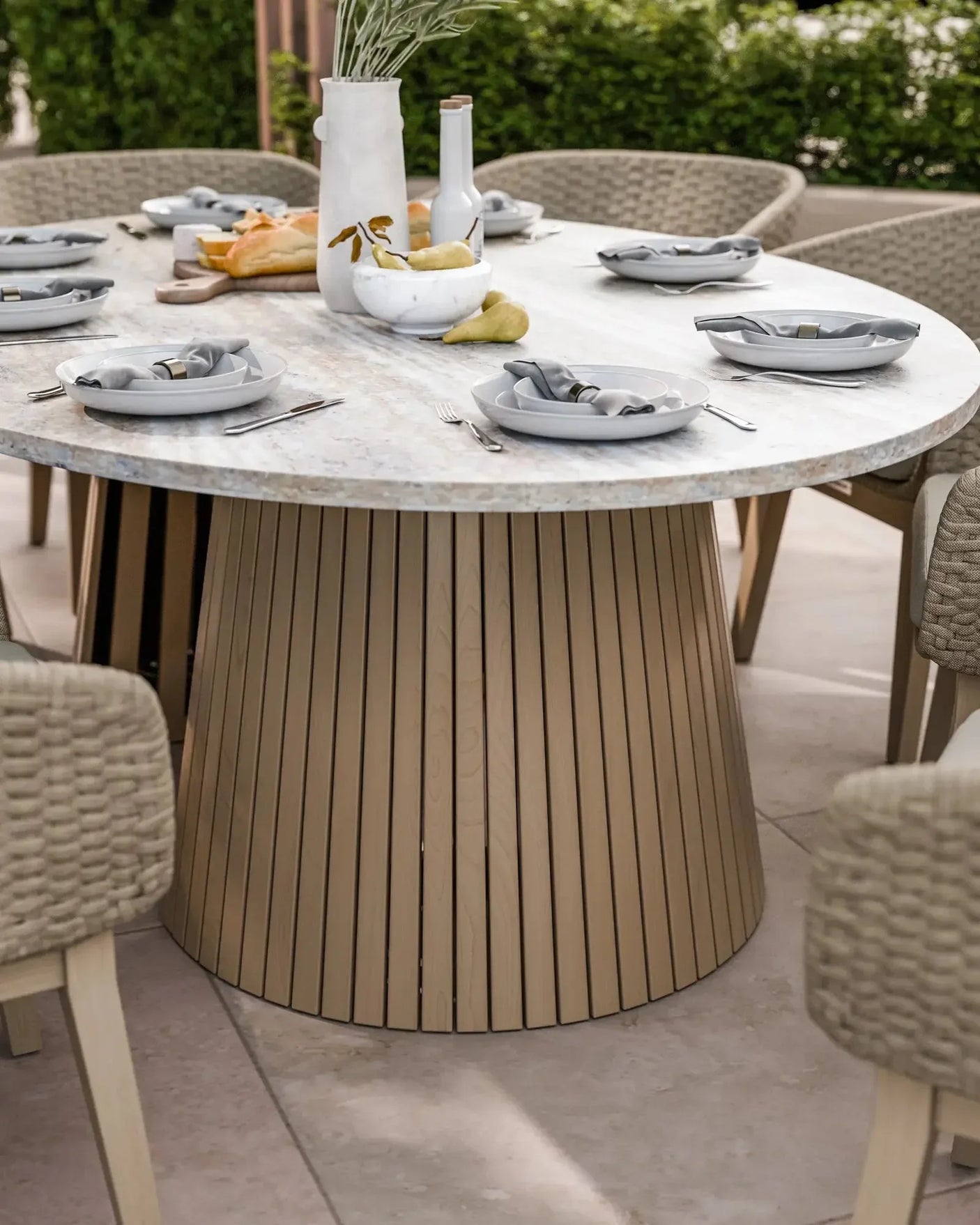 Round marble dining table with slatted wood base set for six with neutral plates and napkins