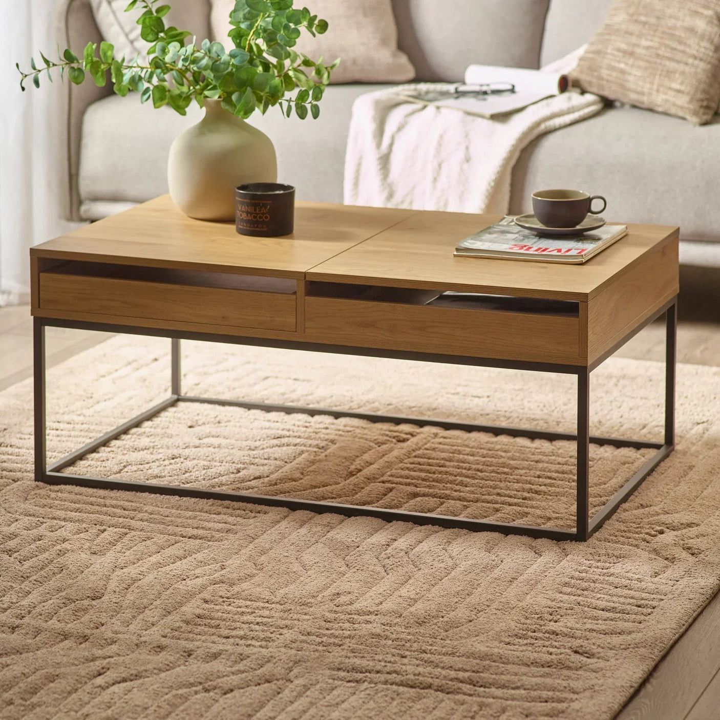 Oak coffee table with black metal legs, two drawers, styled in living room on beige rug