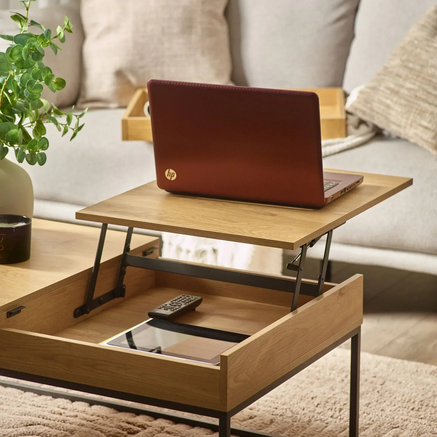 Oak lift top coffee table with black metal frame, open storage holding remote and tablet