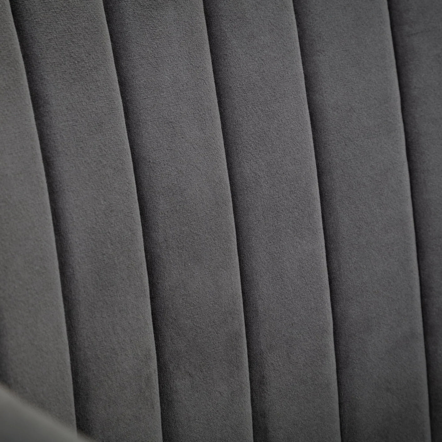 Grey office chair with soft velvet upholstery and vertical stitched detail close-up