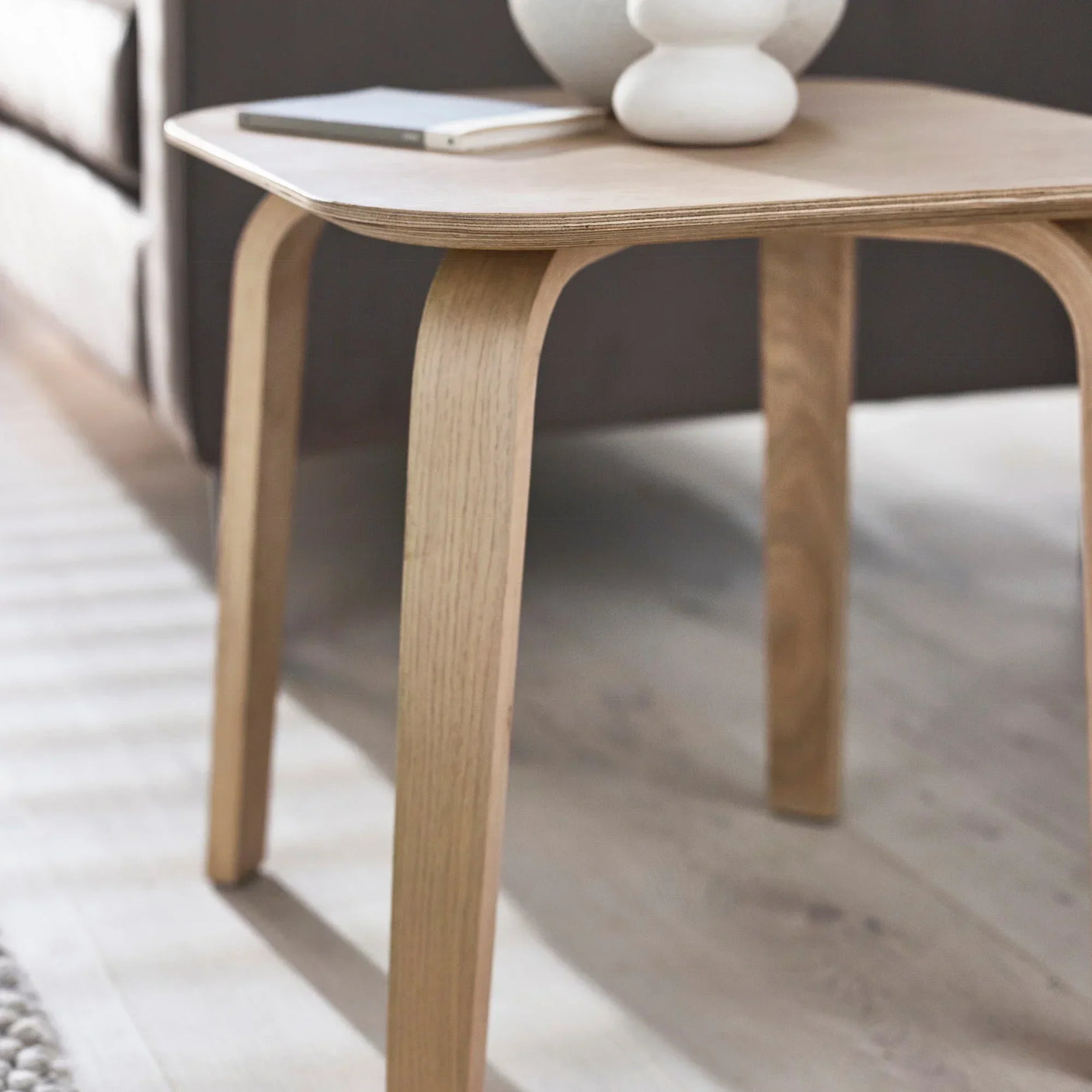 Light wood Kaito side table with curved legs and decorative vase on top