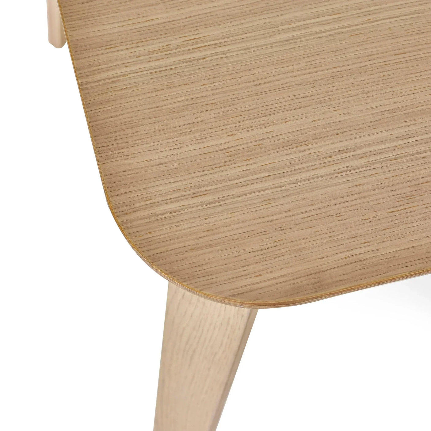 Close-up of oak coffee table corner with rounded edge and visible wood grain detail
