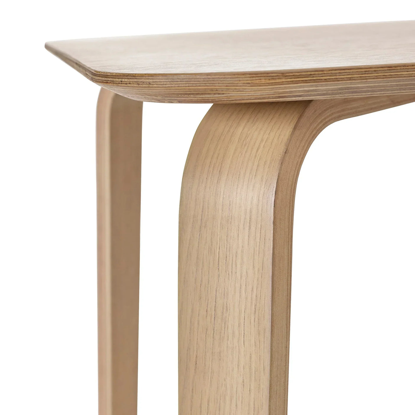 Close-up of Kaito dining table corner showing curved wood leg and light oak finish